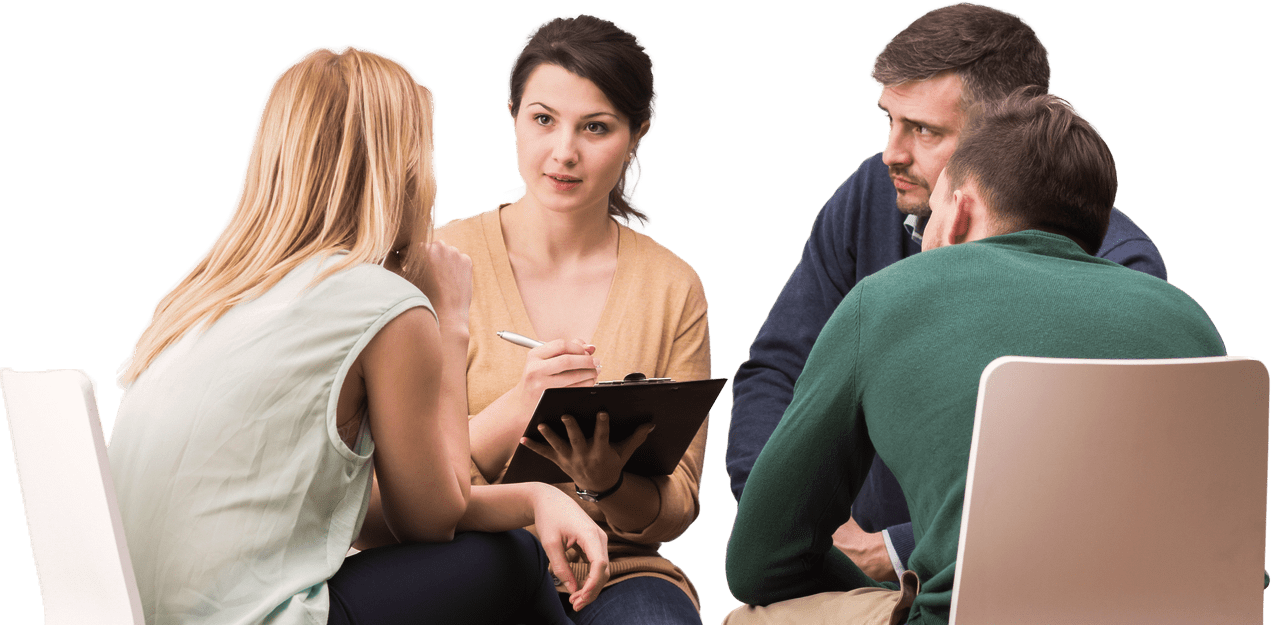 A group discussion with a woman taking notes on a clipboard while three participants engage seriously, emphasizing teamwork and collaboration.